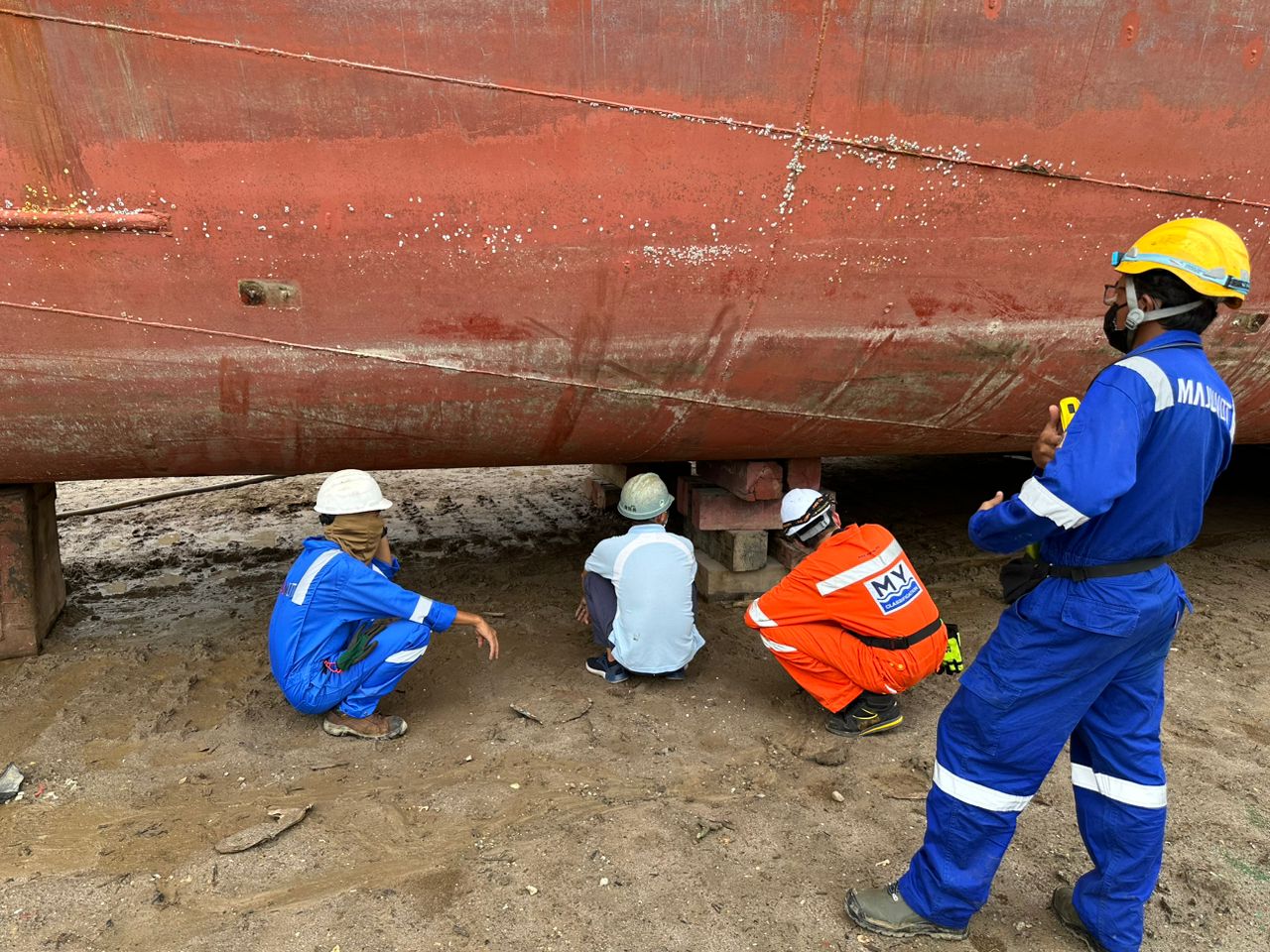 Survey team inspecting a hull bottom on a slipway