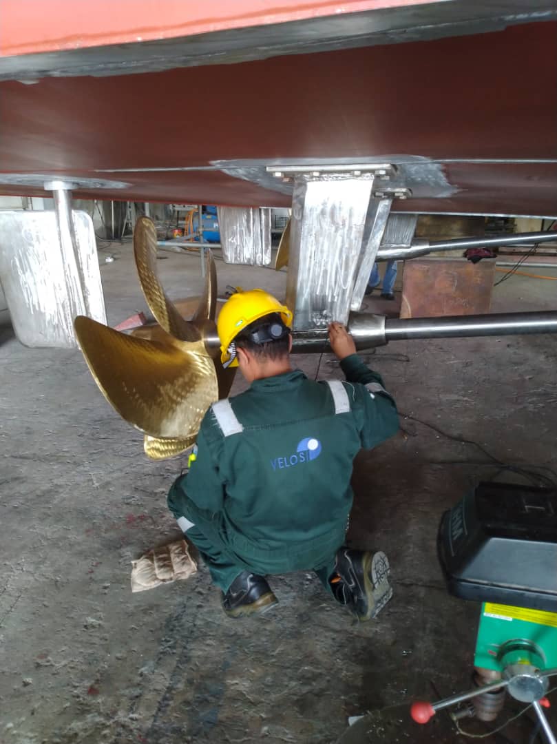 Technician inspecting a vessel's propeller and rudder