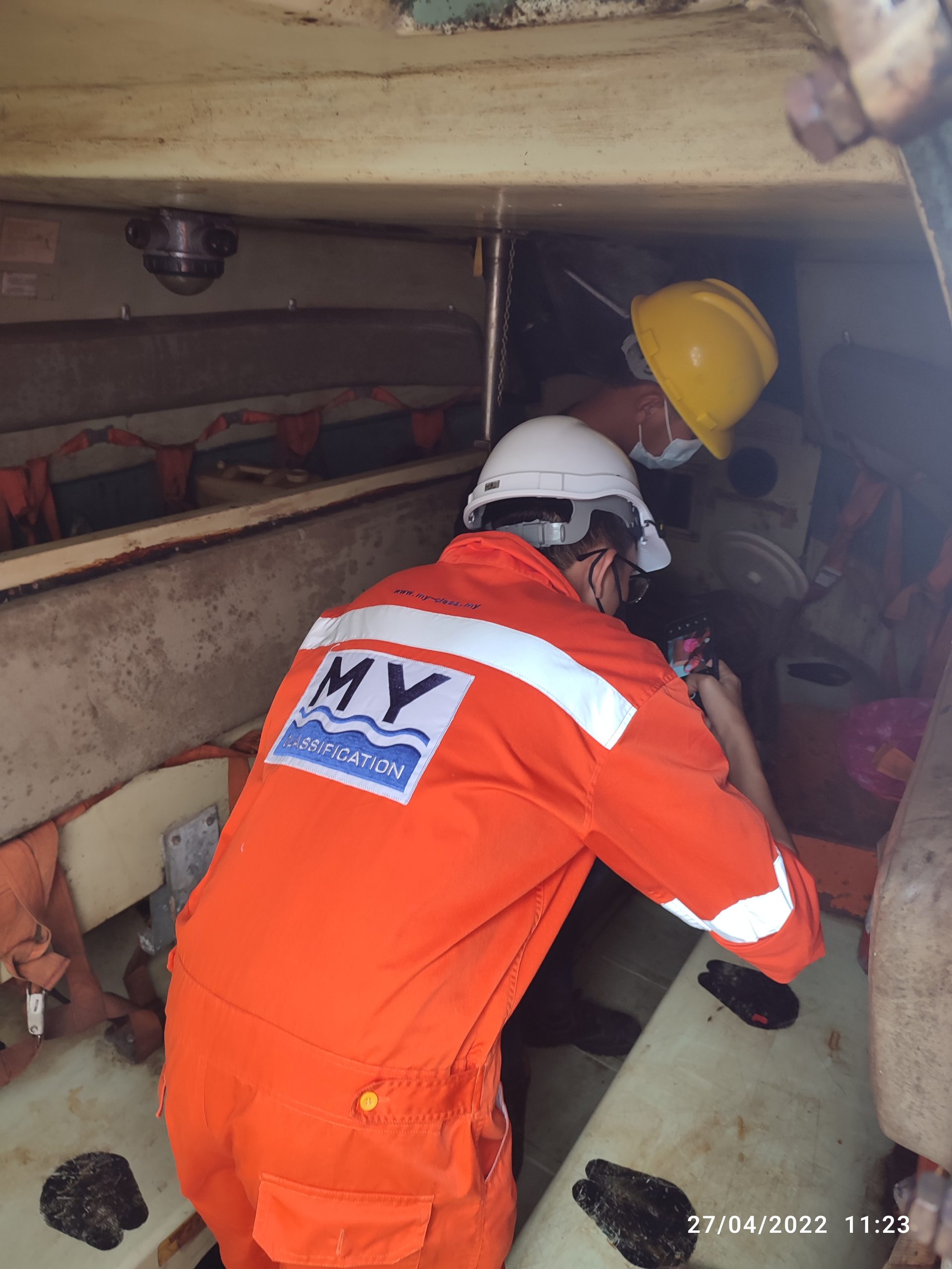 Surveyor inspecting a confined space aboard a vessel
